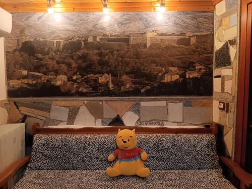 a teddy bear sitting on a bed in a room at Guest House Bake in Gjirokastër