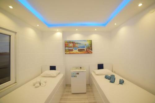 a room with two white tables and a blue ceiling at Ali Baba APART OTEL in Gökçeada