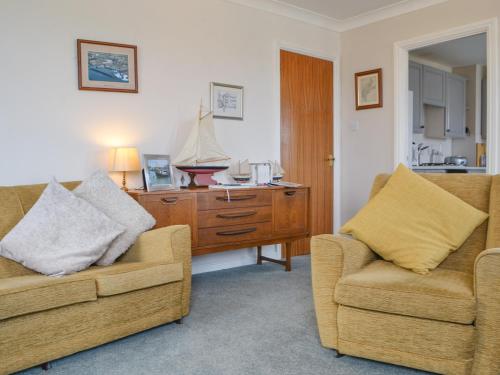 a living room with two chairs and a dresser at Harbour Watch in Maryport