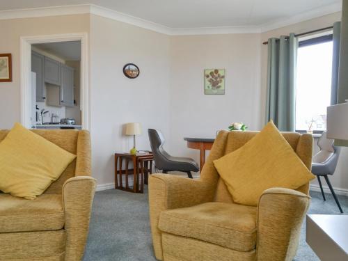 a living room with two chairs and a table at Harbour Watch in Maryport