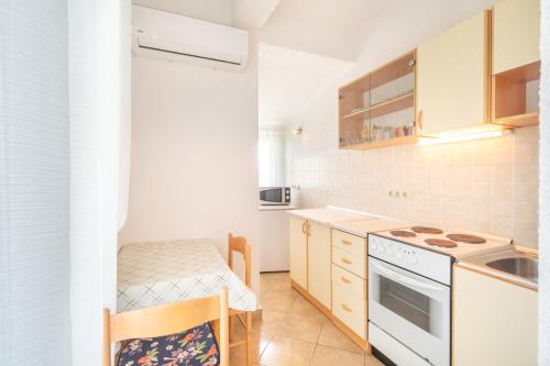 a kitchen with white appliances and a table and chairs at Apartments Katarine Zrinske in Vodice