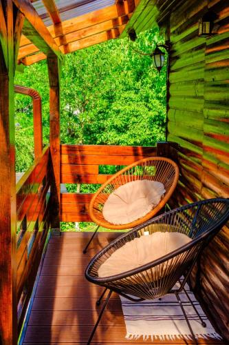 a porch with two chairs on a wooden deck at Casa Bunicii in Costeşti