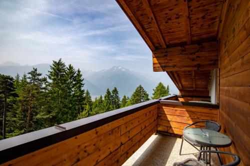 a balcony with a table and chairs and a mountain at Hotel Pension Tyrol in Seefeld in Tirol