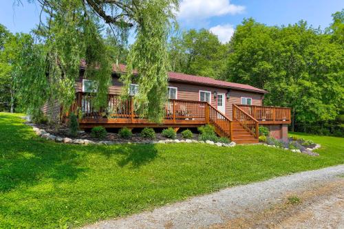 ein Haus mit einer großen Terrasse auf einem Hof in der Unterkunft Delaware River Access Peaceful Farm Retreat! in Callicoon