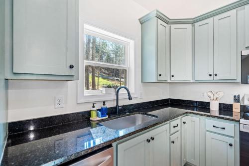 a kitchen with white cabinets and a sink at Creekside Cabin, Sauna, Near Wineries and BJ Reece in Talking Rock