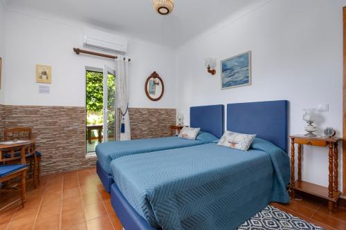 a bedroom with two beds and a table at Casa Flor do Mar Lagos in Lagos