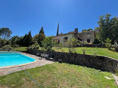 une cour arrière avec une piscine et une maison dans l'établissement Chambres d'hôtes B&B Le Chant des Pins en Cévennes, à Le Collet-de-Dèze