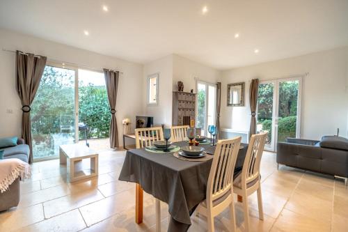 un salon avec une table, des chaises et un canapé dans l'établissement Nice air-conditioned house with flower garden, au Plan-de-la-Tour