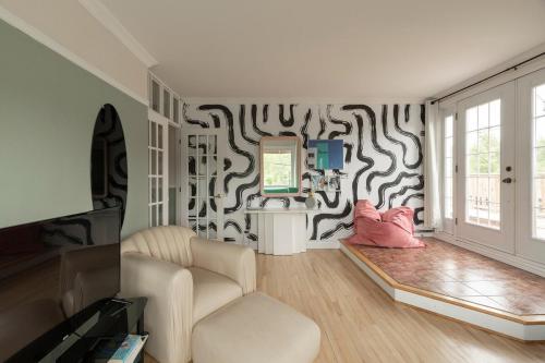 a living room with a couch and a tv at #Le80ies - Downtown Rooftop - Free shuttle to ski Mountain in Mont-Tremblant