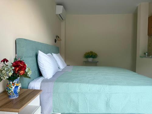 a bedroom with a large bed with a vase of flowers at ELIA in Doukádes