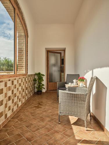 a patio with a table and chairs and a window at Casa Vacanze Santa Caterina in Asciano