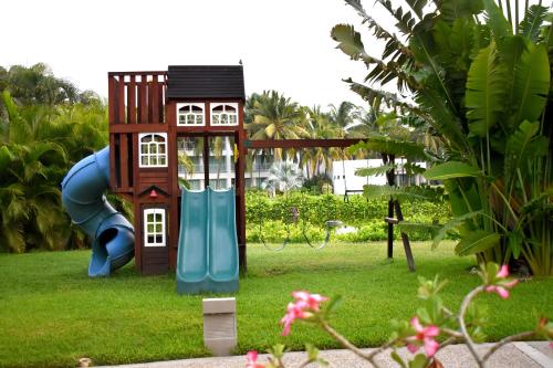 a small playground with a slide in a yard at Departamento Mayan Lakes T6 - Albercas, club de playa, tenis, pádel y más in Acapulco