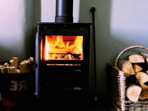 a oven with a fire in it in a room at Southfield Cottage in Braunston