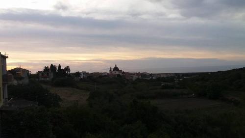 a view of a city on a hill with the sunset at casa di campagna dal pozzo in Sorso