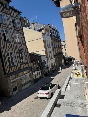 a white car parked on a street with buildings at Le temple, moderne et élégant Cœur de Limoges in Limoges
