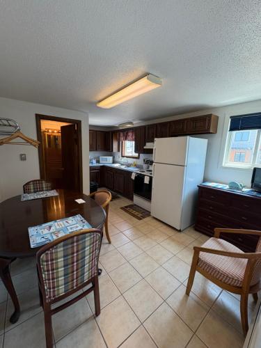 a kitchen with a table and a white refrigerator at Green Dolphin in Old Orchard Beach