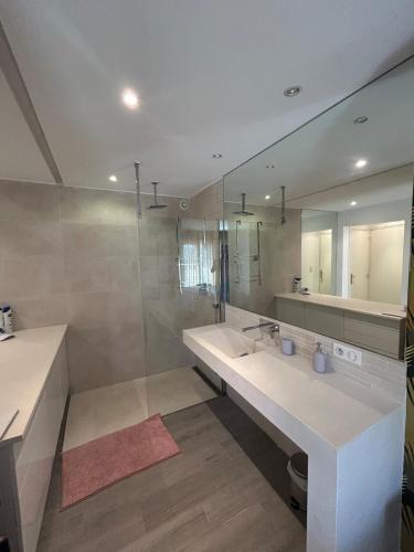 une salle de bain avec deux lavabos et un grand miroir dans l'établissement Très belle vue sur la baie de Bandol, à Bandol