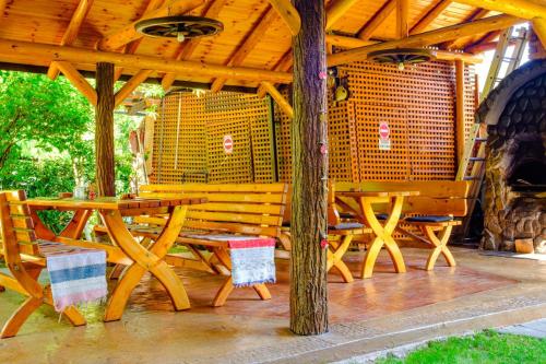 a wooden table and chairs under a wooden roof at Casa Bunicii in Costeşti