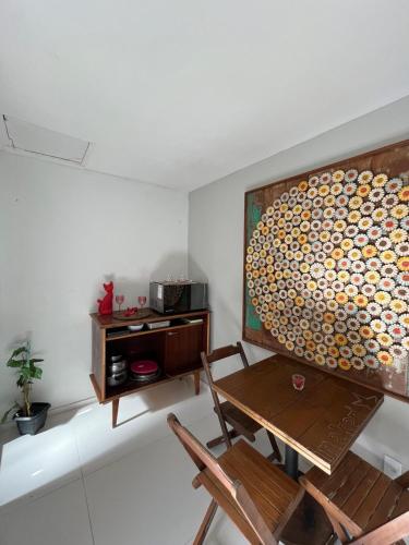 a room with a table and a painting on the wall at Apartamento no Centro de Búzios, 1 minuto de Rua das Pedras e Praia do Canto in Búzios