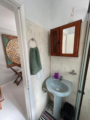 a small bathroom with a sink and a mirror at Apartamento no Centro de Búzios, 1 minuto de Rua das Pedras e Praia do Canto in Búzios