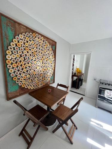 a table and chairs in a room with a painting at Apartamento no Centro de Búzios, 1 minuto de Rua das Pedras e Praia do Canto in Búzios
