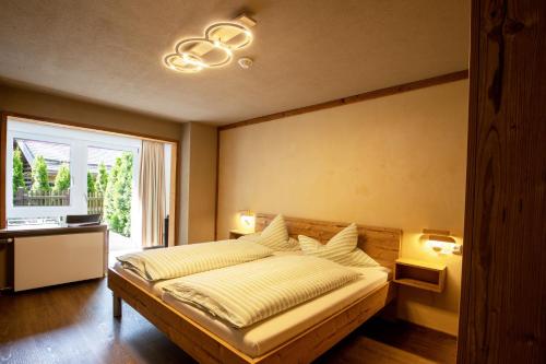 a bedroom with a large bed and a window at Hotel Pension Tyrol in Seefeld in Tirol