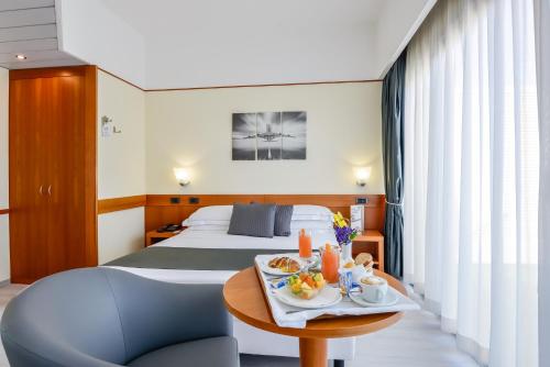 a hotel room with two beds and a table with food on it at Hotel Bologna Airport in Bologna