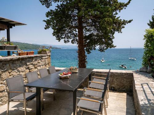 a black table and chairs with a view of the water at Casa Conrad in Opatija