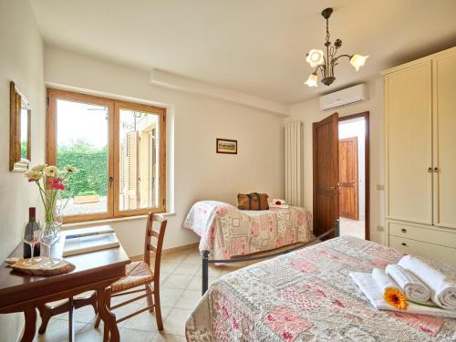a bedroom with a bed and a desk and a table at Casa Vacanze Santa Caterina in Asciano