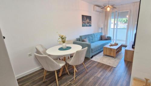 Una sala de estar con una mesa y sillas y un sofá. en kotor apartman 3, en Kravlja