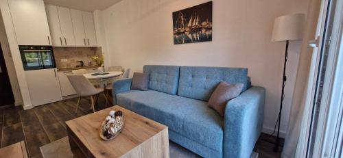 Una sala de estar con un sofá azul y una mesa. en kotor apartman 3, en Kravlja