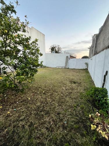 an empty yard with a white wall at Casa en alquiler in Tandil