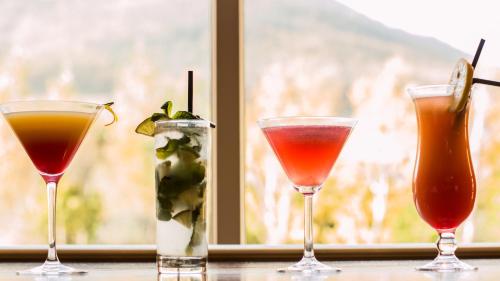 three cocktails sitting on a table in front of a window at Four Seasons Hotel, Carlingford in Carlingford