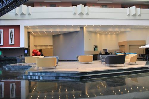 a lobby with chairs and a table and a stage at Holiday Inn Mexico Dali Airport by IHG in Mexico City