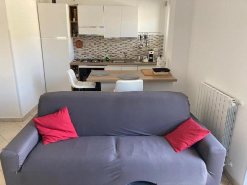 eine blaue Couch mit zwei roten Kissen in der Küche in der Unterkunft Appartamento Bellavista in Roccella Ionica