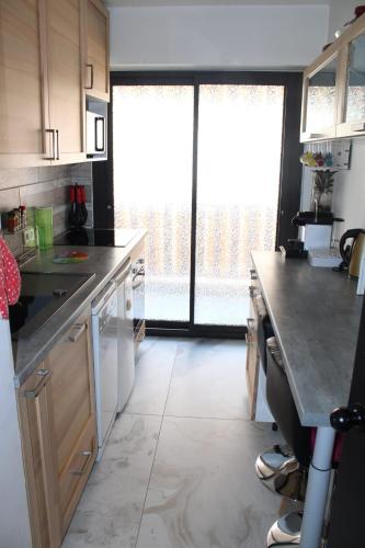 une cuisine avec un comptoir et une grande fenêtre dans l'établissement La Baronne Apartment, à Cannes