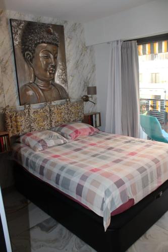 un lit avec une grande statue d'une tête dans l'établissement La Baronne Apartment, à Cannes