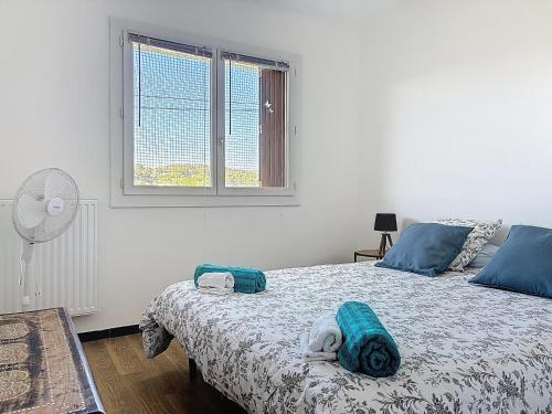 une chambre avec un lit avec des oreillers bleus et une fenêtre dans l'établissement Coeur de Mar Vivo, à La Seyne-sur-Mer