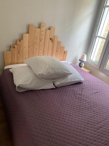 グランカン・メジーにあるAppartement front de merのベッドルーム1室(木製ヘッドボードと枕付きのベッド1台付)