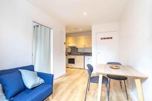 un salon avec un canapé bleu et une table dans l'établissement Jean Jaurès - 2 pièces au pied du métro, à Toulouse