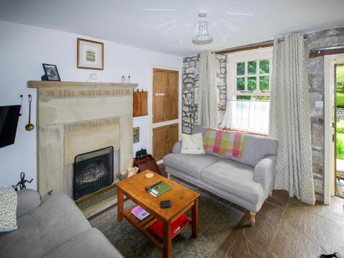 a living room with a couch and a fireplace at Spoutscroft Cottage in Austwick