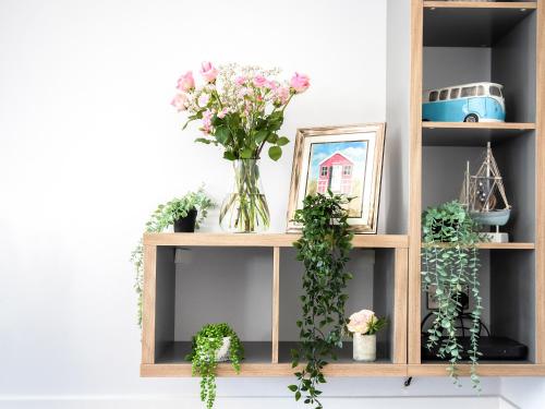 a wooden shelf with flowers and plants on it at Seascape in Sheringham