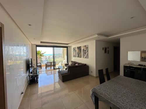 a living room with a couch and a table at Prestigia plage des nations in Sale