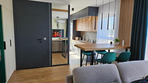 a kitchen and dining room with a table and chairs at Jeziorna Green Apartment in Siewierz