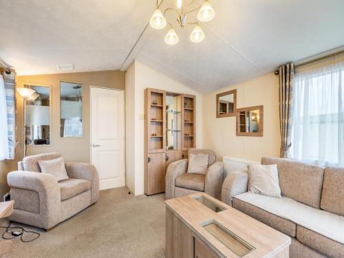 ein Wohnzimmer mit Sofa, Stühlen und einem Tisch in der Unterkunft Coastal Retreat in Ilfracombe