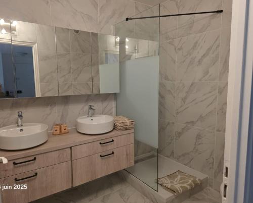 a bathroom with two sinks and a glass shower at La Pineda de Provence in Aix-en-Provence