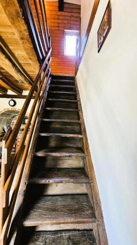 a flight of stairs in a building with a window at Gîte de France à Saint-Martin-la-Méanne 2 épis - Gîte de France 5 personnes MAE-9854 in Saint-Bazile-de-la-Roche