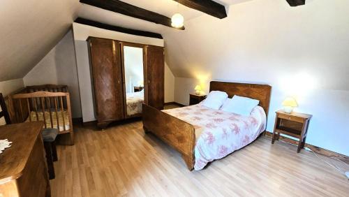 a bedroom with a large bed and a wooden floor at Gîte de France à Saint-Martin-la-Méanne 2 épis - Gîte de France 5 personnes MAE-9854 in Saint-Bazile-de-la-Roche
