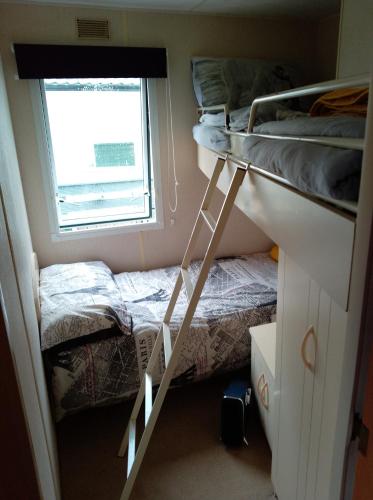 a bedroom with two bunk beds and a window at Cairnryan Loch View in Cairnryan