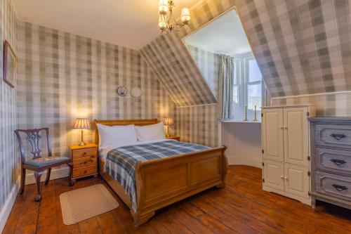 a bedroom with a bed and a chair and a mirror at St Andrews House in Fort William